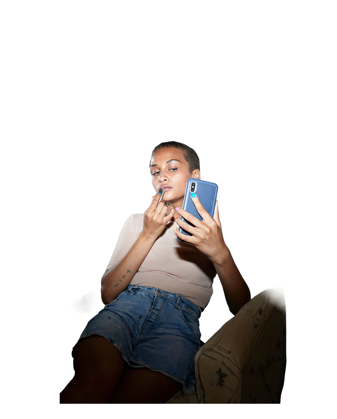 Joven usando su teléfono mientras se maquilla